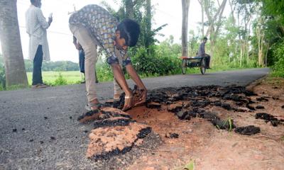 হাত দিয়ে টান দিলেই উঠে যাচ্ছে পিচ ঢালাই রাস্তা!